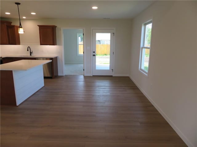 902 2nd St, Perry, KS 66073 - kitchen featuring a sink, dark wood-type flooring, backsplash, light countertops, and baseboards