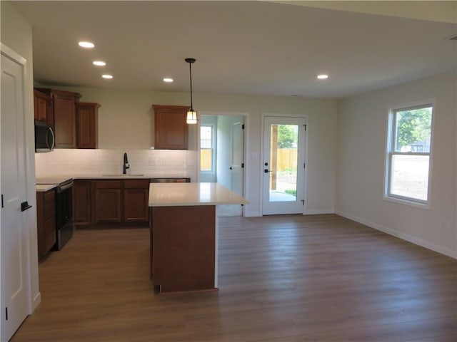 902 2nd St, Perry, KS 66073 - kitchen featuring electric range, black microwave, a sink, wood finished floors, and a center island
