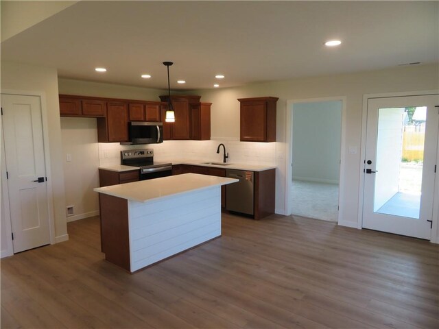 902 2nd St, Perry, KS 66073 - kitchen featuring appliances with stainless steel finishes, a sink, backsplash, wood finished floors, and recessed lighting