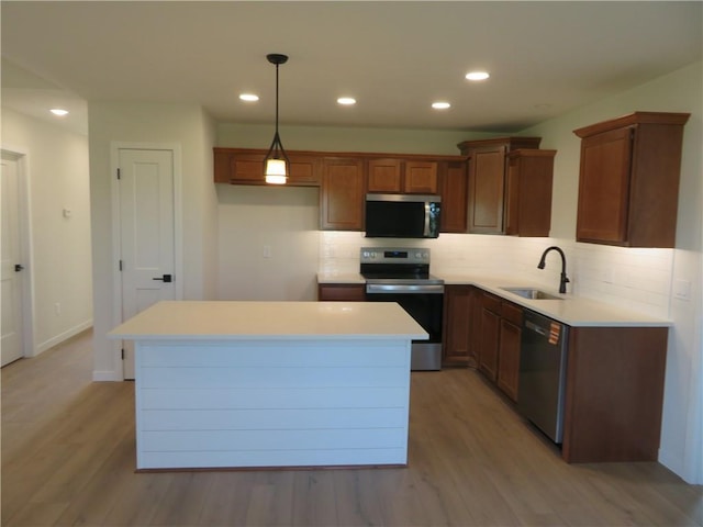 902 2nd St, Perry, KS 66073 - kitchen featuring stainless steel appliances, a sink, light wood-type flooring, decorative backsplash, and light countertops