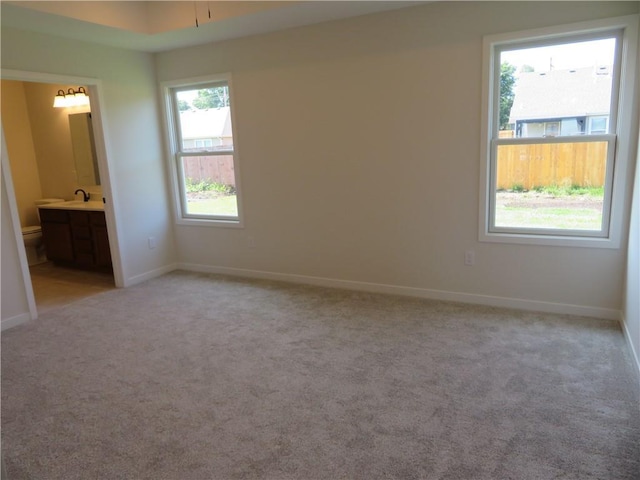 902 2nd St, Perry, KS 66073 - unfurnished bedroom with a sink, light carpet, baseboards, and ensuite bath