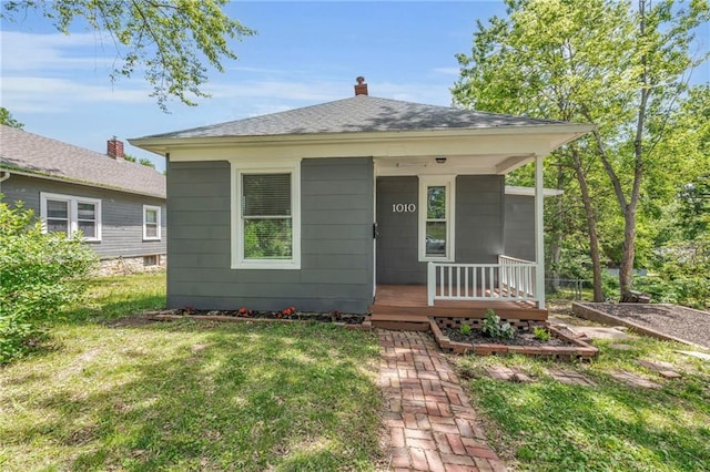 1010 N 13th St, Leavenworth, KS 66048 - bungalow-style house with a porch, a front lawn, a chimney, and roof with shingles