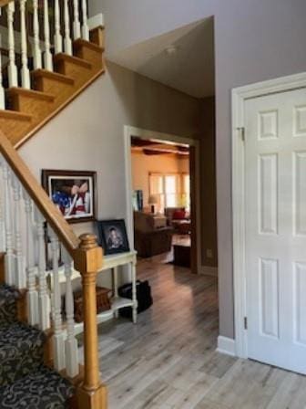 staircase featuring wood finished floors and baseboards