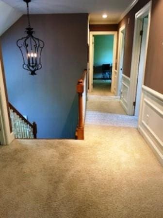 stairs with carpet and a chandelier