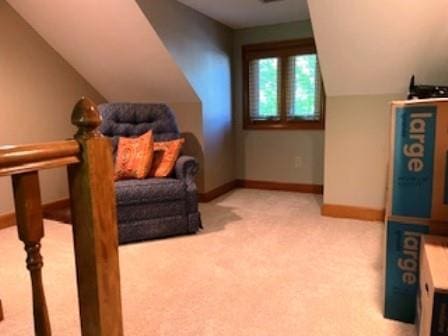 living area featuring carpet floors, baseboards, and lofted ceiling