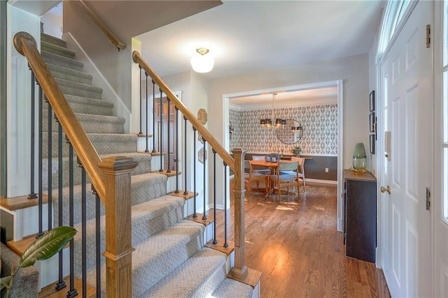 2007 NE Newport Ct, Blue Springs, MO 64014 - stairway featuring a chandelier, wood finished floors, baseboards, and wallpapered walls
