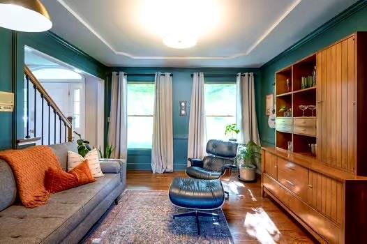 2007 NE Newport Ct, Blue Springs, MO 64014 - living area with wood finished floors, healthy amount of natural light, a tray ceiling, and stairs