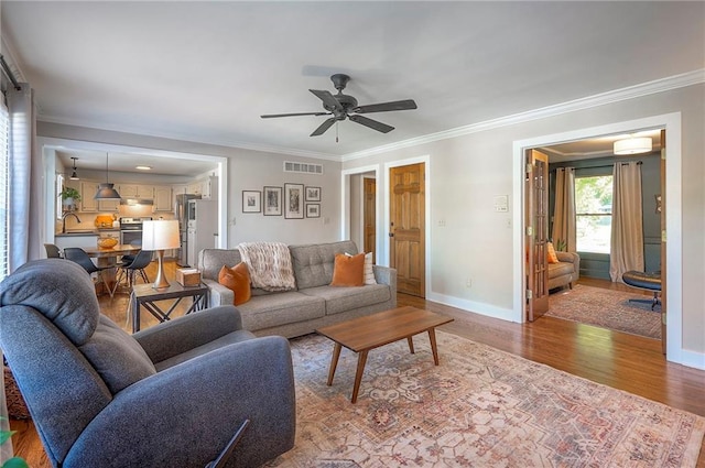 2007 NE Newport Ct, Blue Springs, MO 64014 - living room with crown molding, baseboards, wood finished floors, ceiling fan, and an AC wall unit