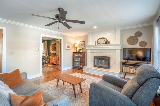 2007 NE Newport Ct, Blue Springs, MO 64014 - living room featuring ornamental molding, wood finished floors, baseboards, ceiling fan, and a large fireplace