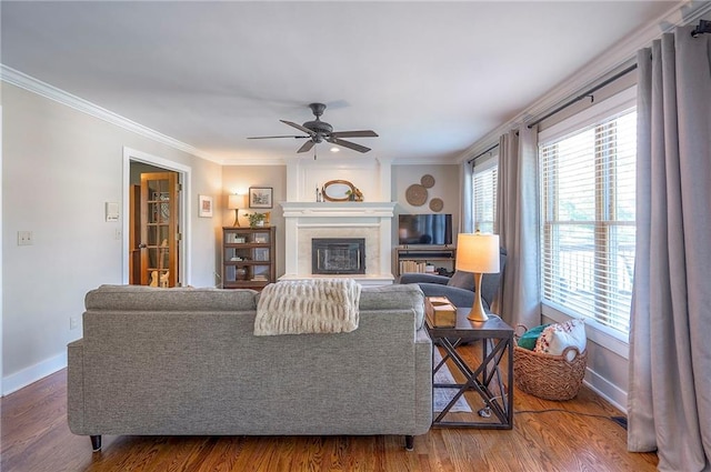 2007 NE Newport Ct, Blue Springs, MO 64014 - living room with baseboards, ceiling fan, wood finished floors, ornamental molding, and a glass covered fireplace