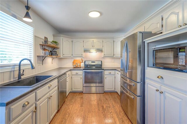 2007 NE Newport Ct, Blue Springs, MO 64014 - kitchen featuring stainless steel appliances, a sink, under cabinet range hood, light wood finished floors, and open shelves