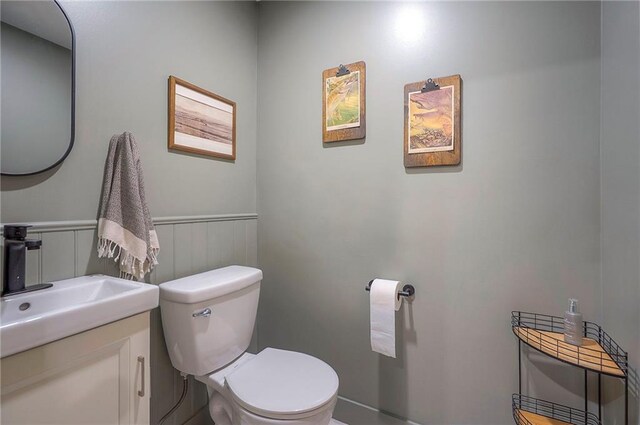 2007 NE Newport Ct, Blue Springs, MO 64014 - half bathroom featuring toilet, vanity, and wainscoting