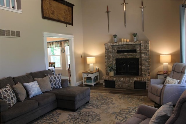 1658 NW 785th Rd, Bates City, MO 64011 - living room featuring a towering ceiling, a brick fireplace, wood finished floors, and baseboards