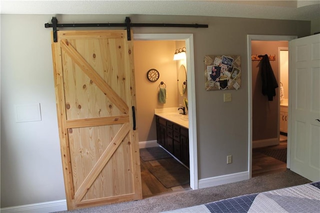 1658 NW 785th Rd, Bates City, MO 64011 - bedroom with a barn door, baseboards, and ensuite bathroom