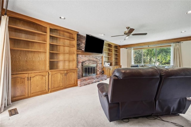 living area featuring light carpet, ceiling fan, recessed lighting, a textured ceiling, and a brick fireplace