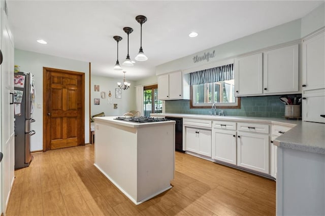 kitchen featuring stainless steel appliances, a kitchen island, backsplash, white cabinets, and recessed lighting