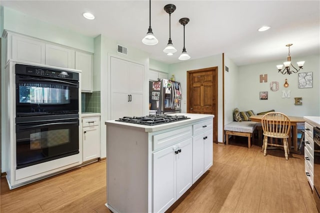 kitchen with stainless steel fridge, gas stovetop, light wood-type flooring, white cabinets, and recessed lighting
