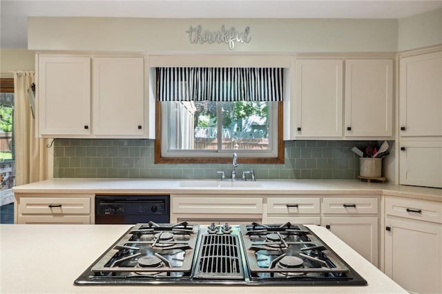 kitchen featuring black appliances, light countertops, a sink, and white cabinets