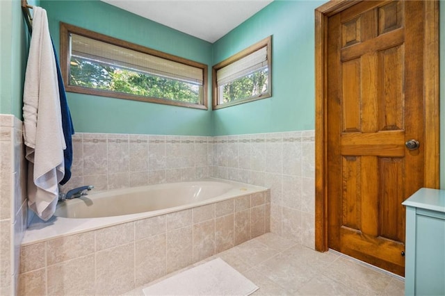 bathroom with healthy amount of natural light, a bath, and tile patterned floors
