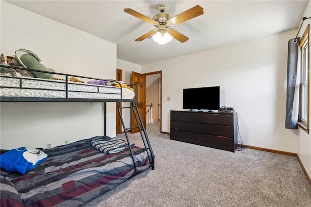 carpeted bedroom featuring baseboards and a ceiling fan