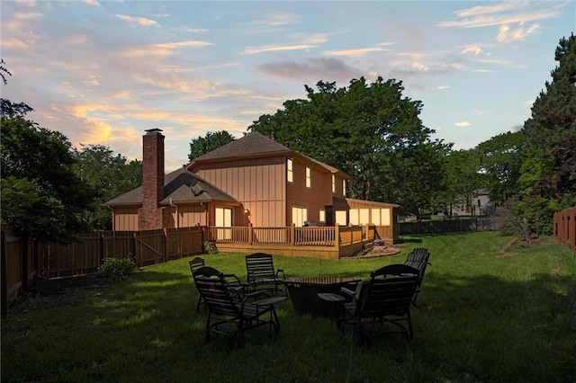 rear view of property featuring a chimney and a deck