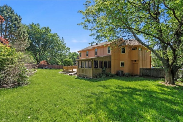 rear view of property featuring a sunroom, central AC, and board and batten siding
