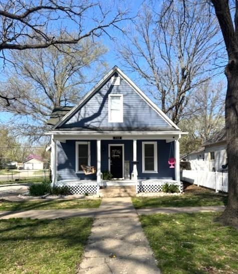 bungalow-style home featuring a porch and fence