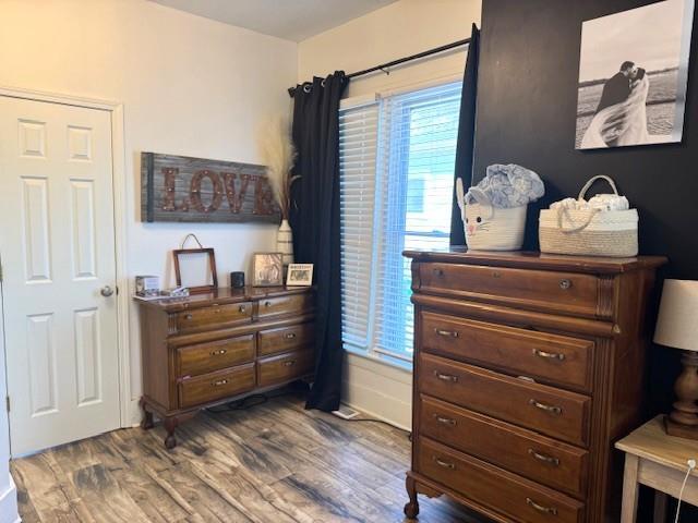 bedroom with dark wood finished floors and baseboards
