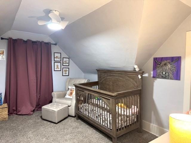 carpeted bedroom featuring lofted ceiling, ceiling fan, and a nursery area
