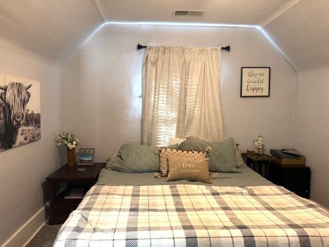bedroom featuring vaulted ceiling and carpet flooring