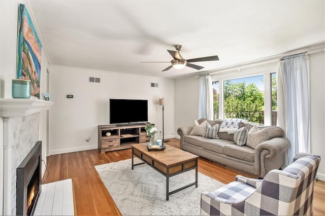 7408 Ash St, Prairie Village, KS 66208 - living area featuring a tiled fireplace, ceiling fan, baseboards, and wood finished floors
