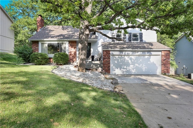 view of front of house featuring brick siding, driveway, a front yard, a chimney, and a garage