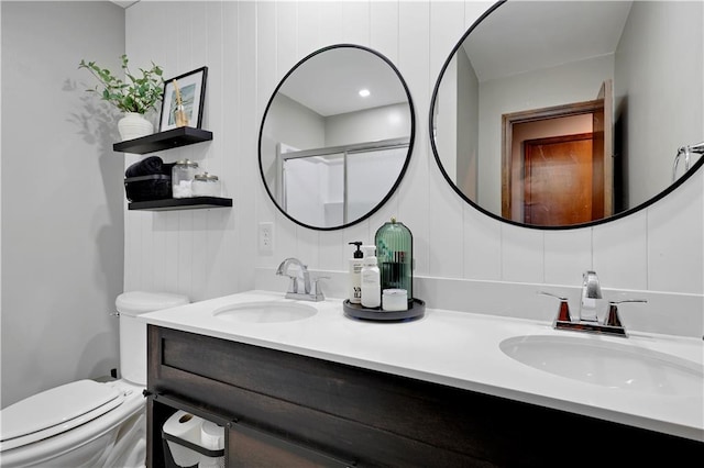 full bath with toilet, double vanity, and a shower with shower door