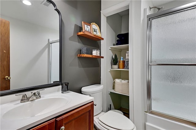 bathroom featuring an enclosed shower, vanity, and toilet