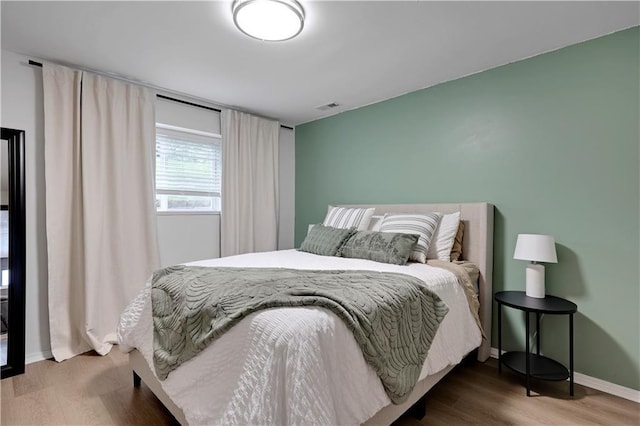 bedroom with wood finished floors and baseboards
