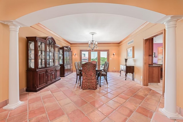 dining space featuring ornate columns, arched walkways, crown molding, a chandelier, and baseboards
