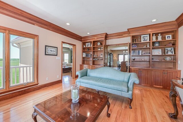 living room with crown molding, light wood finished floors, arched walkways, recessed lighting, and baseboards