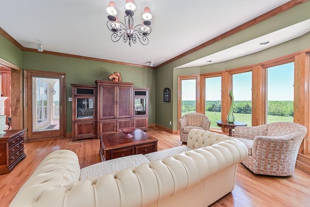 living area featuring a chandelier, light wood finished floors, ornamental molding, and baseboards