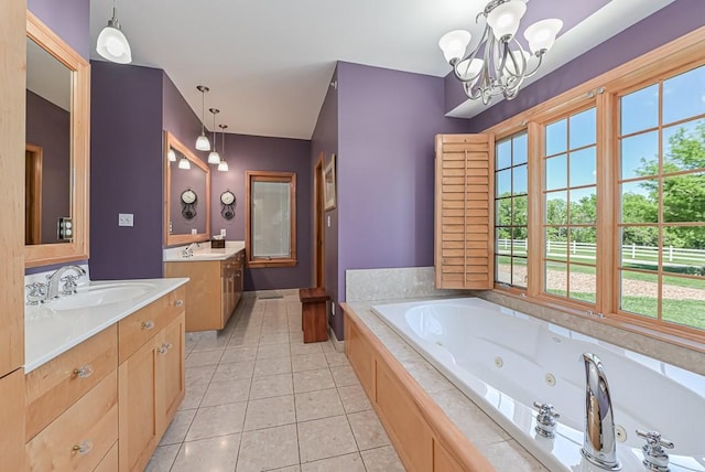 full bath featuring plenty of natural light, tile patterned flooring, a chandelier, and a tub with jets