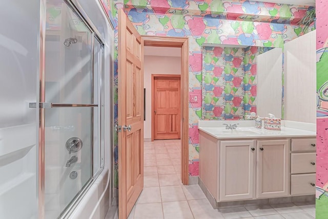 full bath with tile patterned floors, vanity, and bath / shower combo with glass door