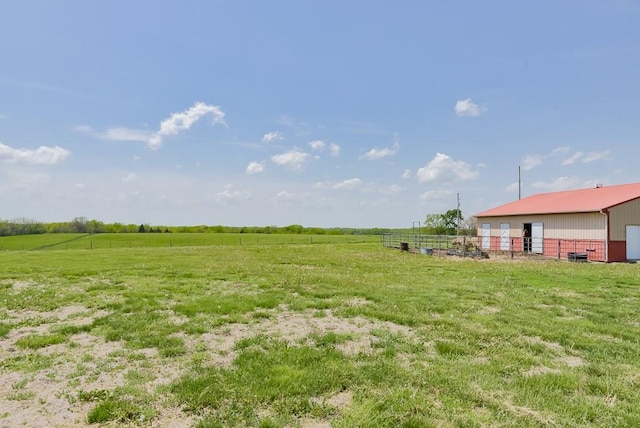 view of yard with an outdoor structure, a rural view, an exterior structure, and an outbuilding
