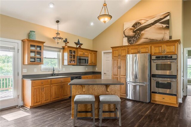 23780 Moberly Rd, Polo, MO 64671 - kitchen with stainless steel appliances, dark countertops, a sink, brown cabinetry, and high vaulted ceiling