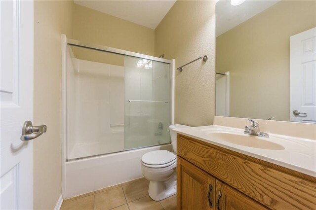 23780 Moberly Rd, Polo, MO 64671 - bathroom featuring tile patterned floors, toilet, vanity, a textured wall, and bath / shower combo with glass door