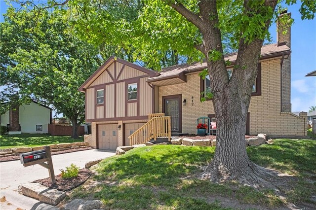 612 S 6th St, Edwardsville, KS 66111 - view of front of property with brick siding, concrete driveway, a garage, a front lawn, and a chimney