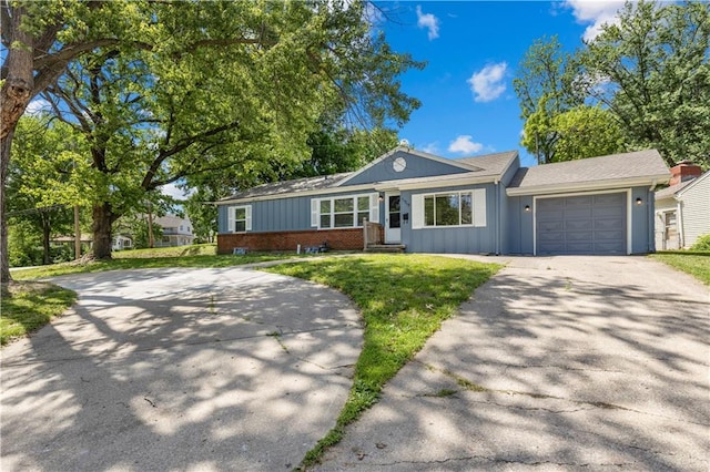 11719 E 30th Ter S, Independence, MO 64052 - ranch-style house with driveway, board and batten siding, a garage, brick siding, and a front lawn