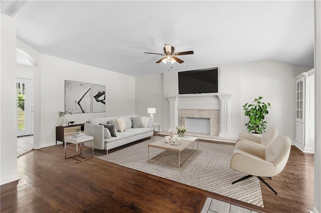 11719 E 30th Ter S, Independence, MO 64052 - living room featuring a ceiling fan, wood finished floors, arched walkways, a fireplace, and baseboards