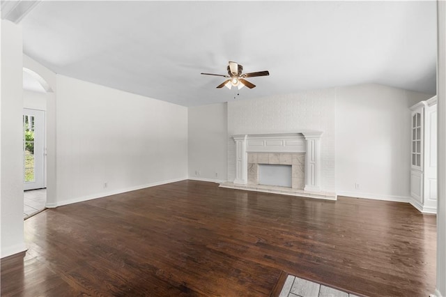 11719 E 30th Ter S, Independence, MO 64052 - unfurnished living room featuring ceiling fan, dark wood-style floors, arched walkways, a fireplace, and vaulted ceiling