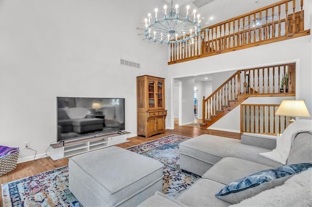 11065 W 98th St, Overland Park, KS 66214 - living area with a chandelier, wood finished floors, a high ceiling, stairs, and recessed lighting