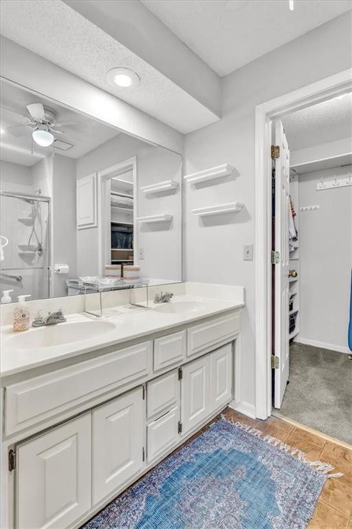 11065 W 98th St, Overland Park, KS 66214 - full bath featuring double vanity, a shower stall, tile patterned flooring, ceiling fan, and recessed lighting
