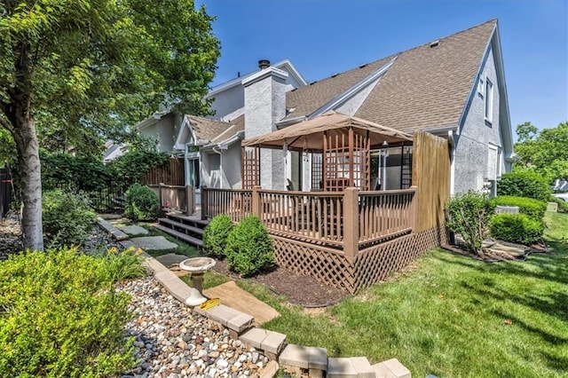11065 W 98th St, Overland Park, KS 66214 - rear view of house with roof with shingles, a deck, a chimney, and a yard